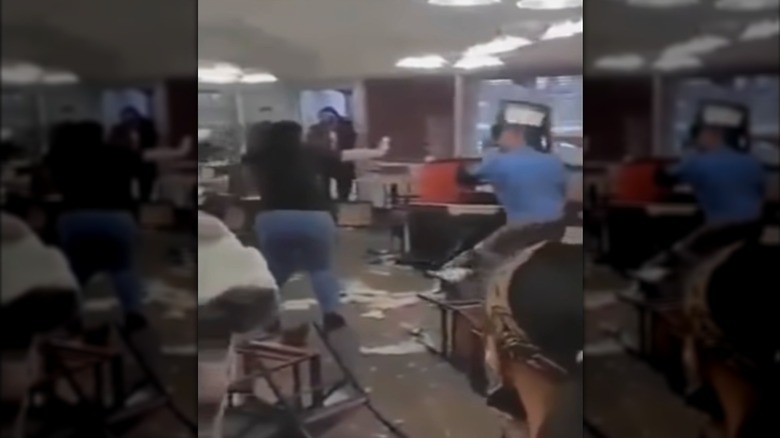A man lifts a chair to throw it during a large brawl inside a Golden Corral dining room