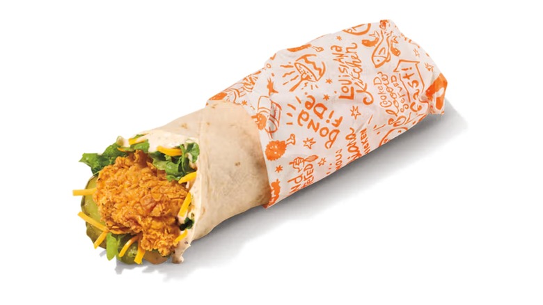 A Popeyes Blackened Ranch Chicken Wrap featuring shredded cheese, leaf lettuce, and pickles