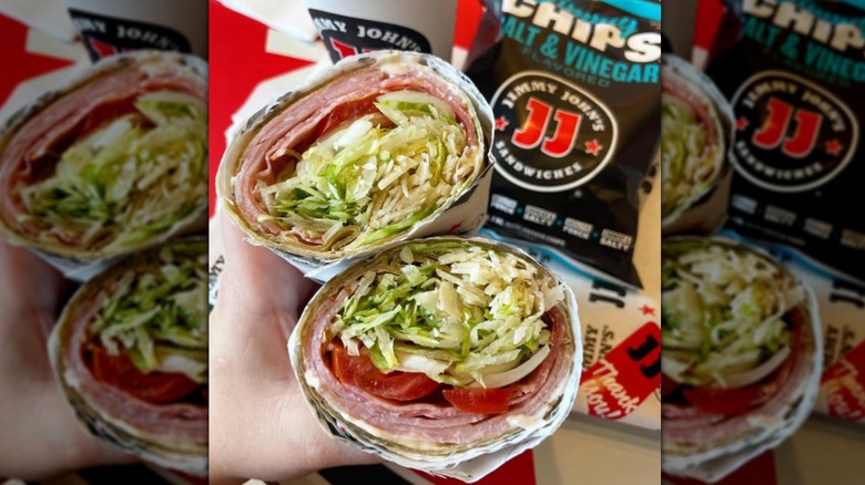 A hand holding both halves of a Jimmy John's Tuscan Italian Wrap