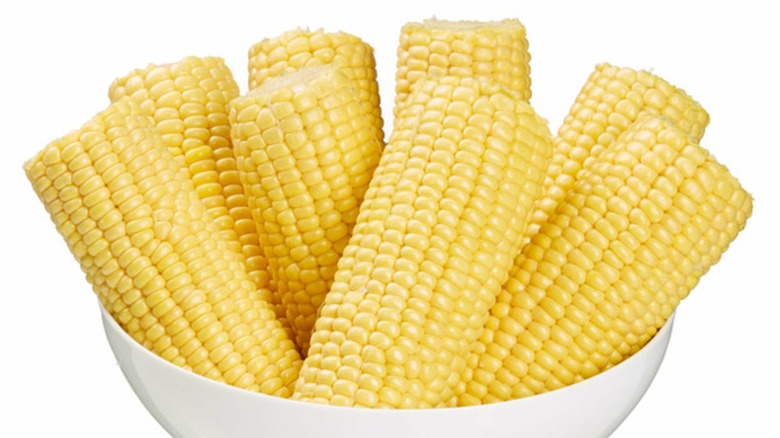 white bowl with 8 ears of shucked corn