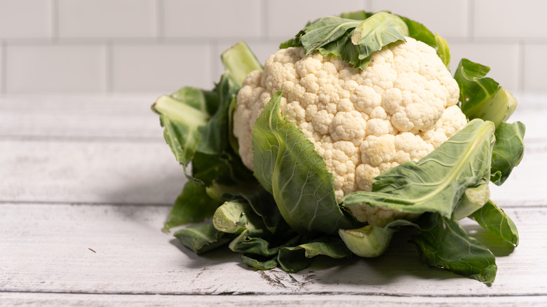 A whole head of cauliflower on a white table