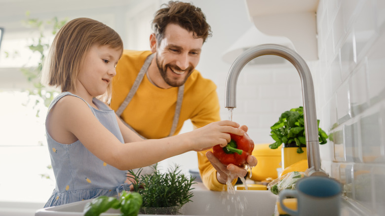 father and daughter washing food