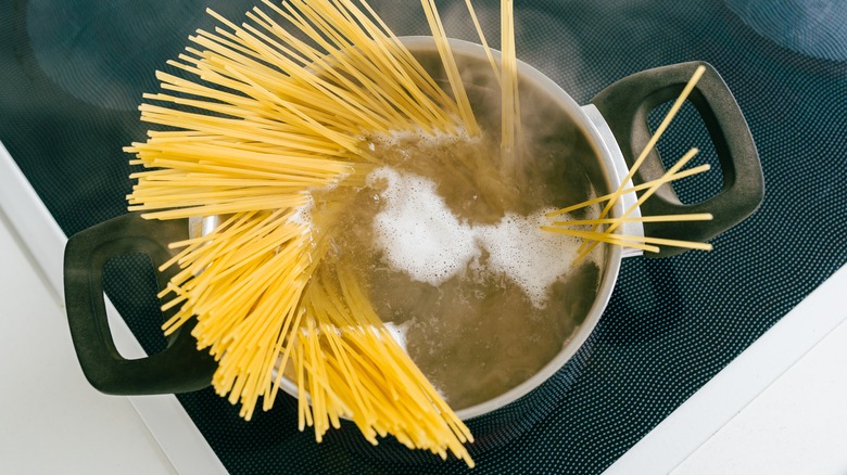 Spaghetti boiling in pot of water