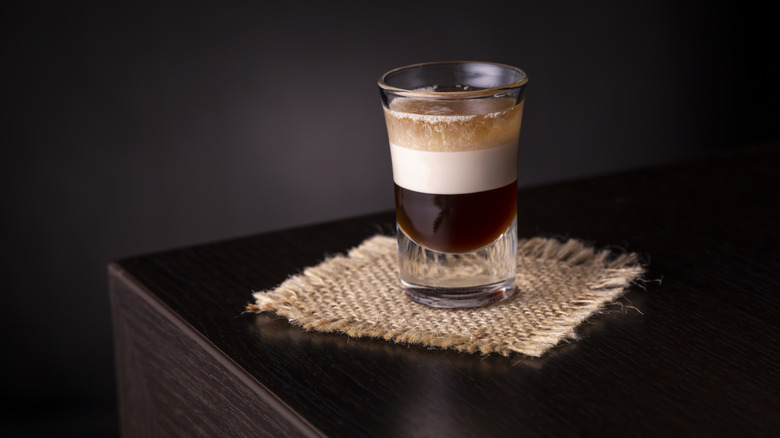 A B-52 cocktail shot posed on a table corner