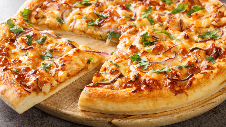 BBQ chicken pizza with a slice cut from it