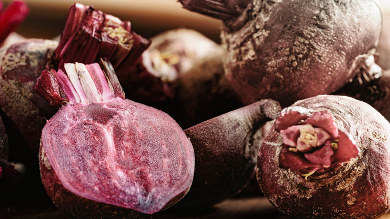 Ripe beets, with one sliced in half to show its purple interior