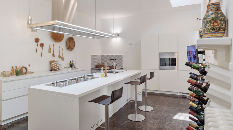 A modern Italian kitchen with an open floor plan, large island, and large wine storage