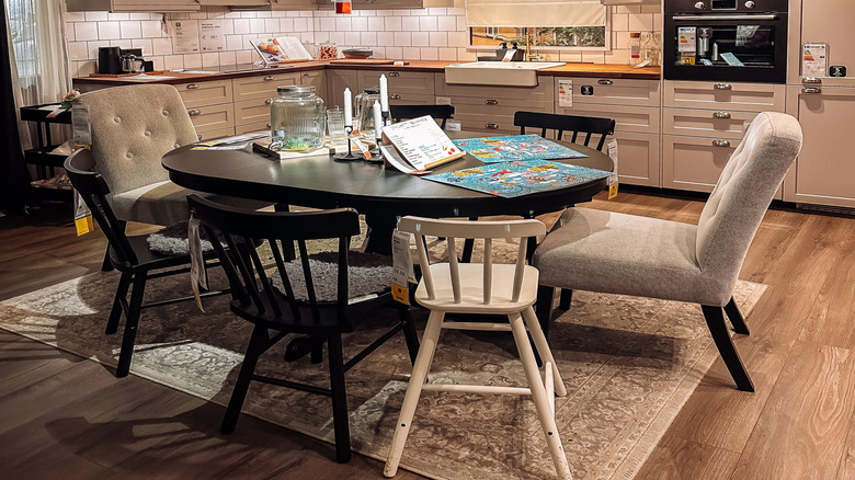 A showroom kitchen with a minimalist, modern chandelier over a table