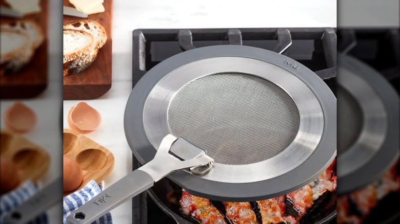 a splatter guard is placed on top of food being fried
