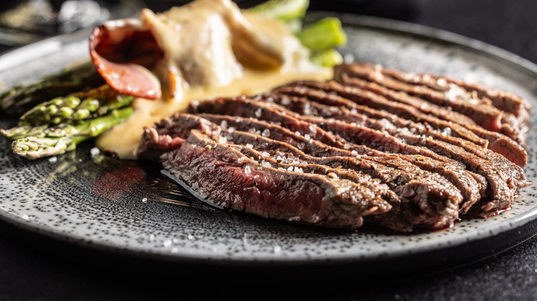 Seared flank steak, sliced into strips and served on a plate