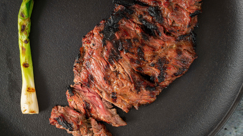 Grilled skirt steak with a grilled green onion