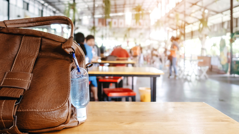 A bag sits on a table in a mall food court