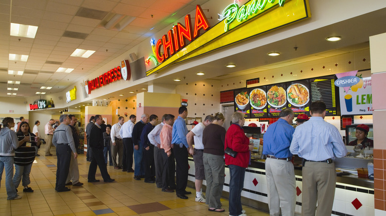 People wait in line at a food court