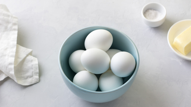 White eggs sit in a blue bowl on a counter