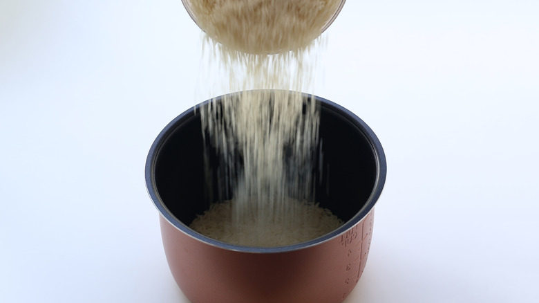 Rice being poured into rice cooker