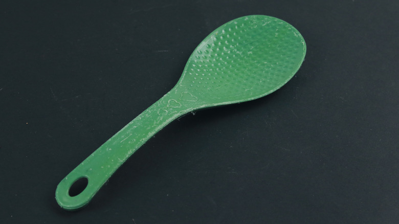 A well-used plastic rice paddle
