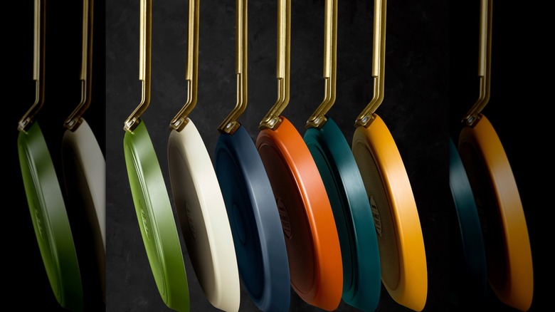 Six of the GreenPan/Tucci crepe pans in various colors, hanging vertically