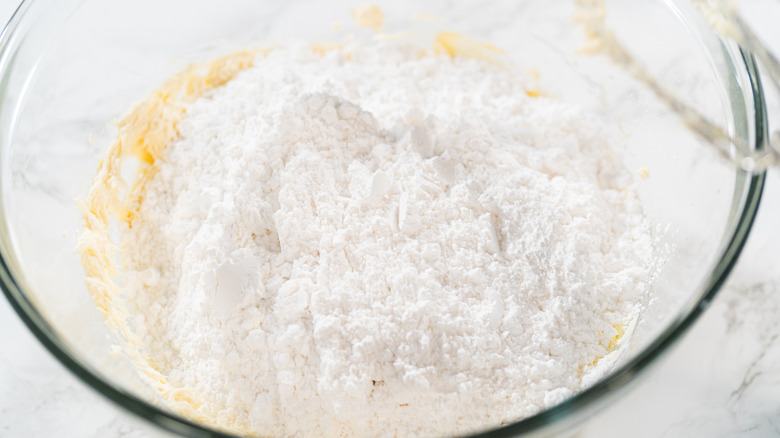 Ingredients for cream cheese icing being mixed in a glass bowl