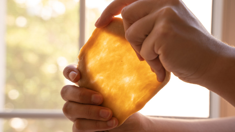 A baker using the windowpane test to see if dough is ready