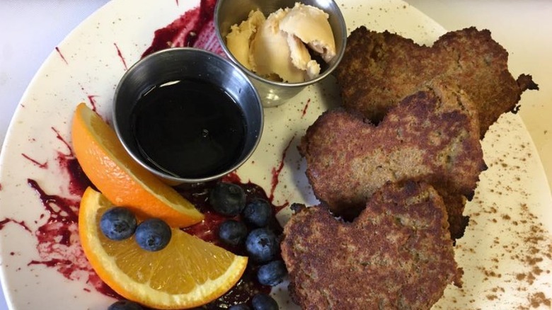 3 pieces of french toast with 2 slices of orange, blueberries, sauce, and icecream