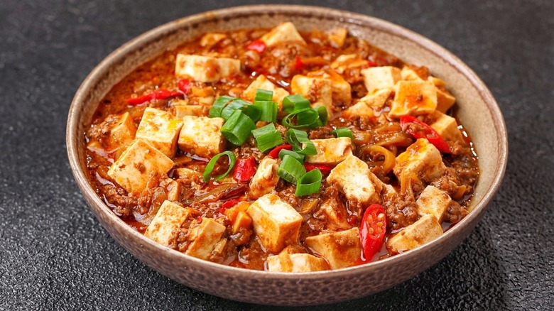 Ceramic bowl of mapo tofu on black table