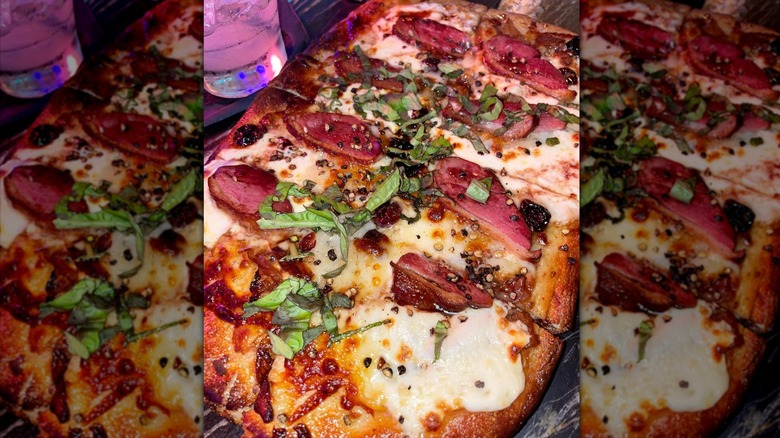 Flatbread pizza with duck bacon, dried cherries, and fresh herbs