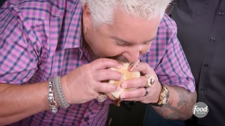 Guy Fieri bites into the Tres Hombres sandwich at ZZQ Texas Craft Barbeque