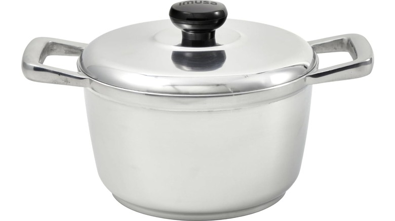An aluminum Dutch oven with a black lid handle and prominent aluminum side handles on the pot against a white background