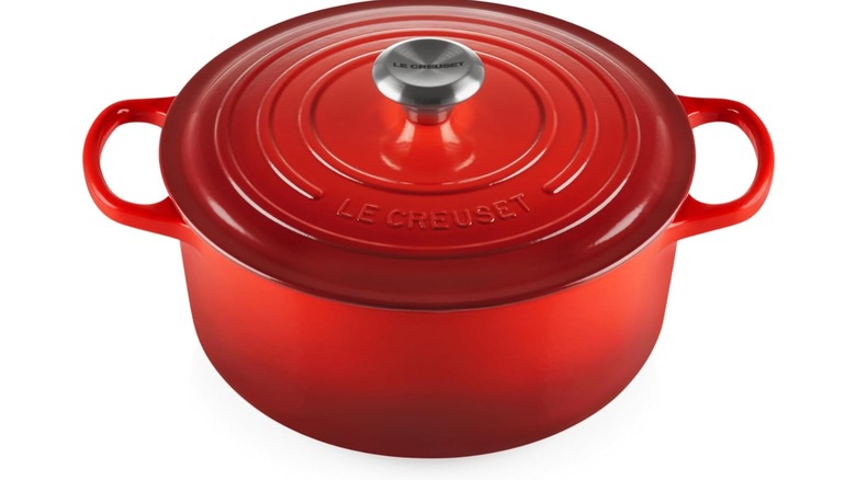 A red, round Dutch oven from Le Creuset against a white background