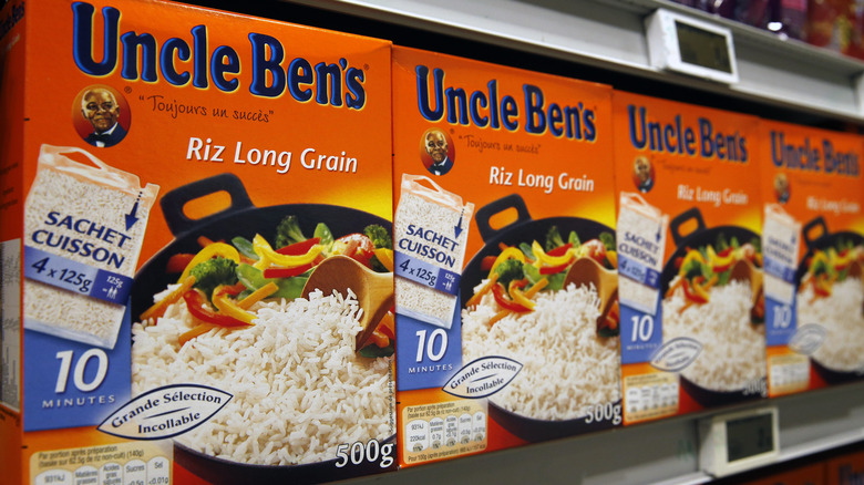 Boxes of Uncle Ben's rice lined up on a grocery store shelf.