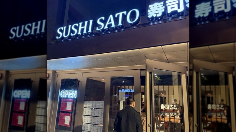 The exterior of Sushi Sato, with a person walking into the restaurant