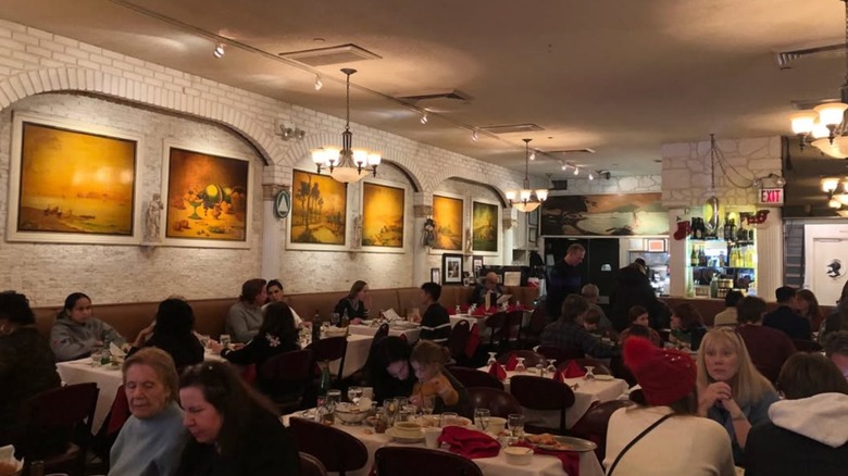 Interior of Mario's restaurant, showing multiple people eating in its dining room