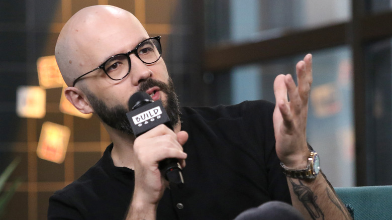 Andrew Rea talking into a microphone