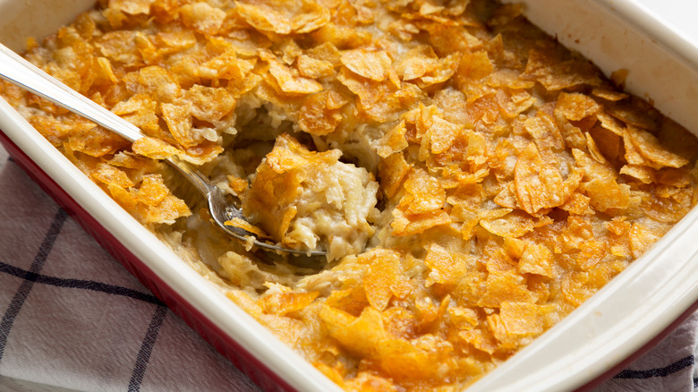 Casserole dish of funeral potatoes being spooned out