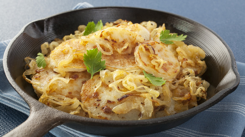 Skillet of Lyonnaise potatoes garnished with fresh parsley