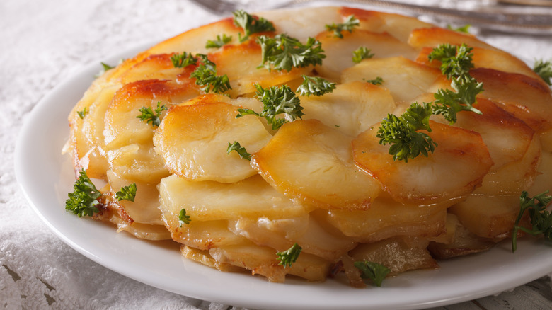 Pommes Anna on a plate, garnished with parsley