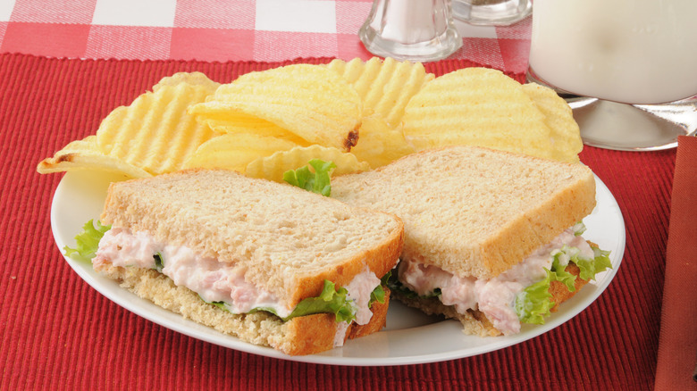Deviled ham sandwich with potato chips and milk
