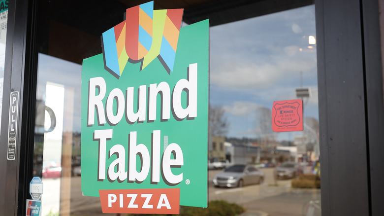 A Round Table Pizza logo is shown on one of its restaurant's doors