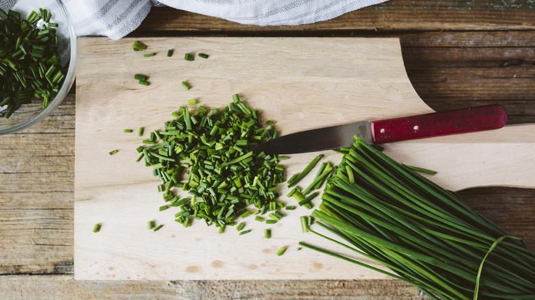 Chives being chopped up on cutting board