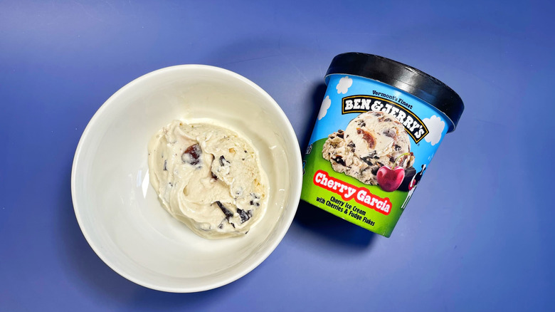 A pint of Cherry Garcia next to a bowl with a scoop