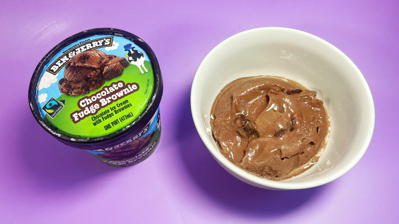 A scoop of Chocolate Fudge Brownie in a bowl next to its container