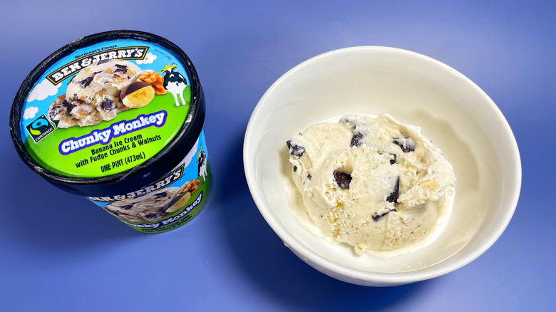 A scoop of Chunky Monkey in a bowl next to its container