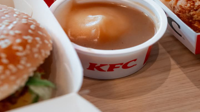 A bowl of mashed potatoes and gravy from KFC on a wooden table