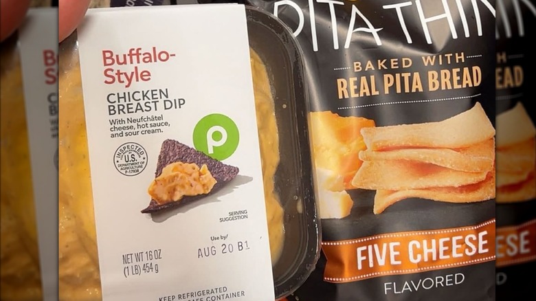 A container of Publix buffalo-style chicken breast dip next to bag of pita thins