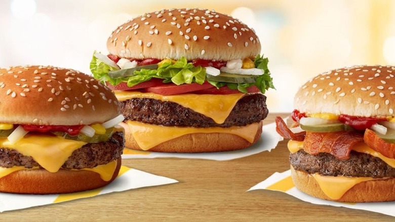 three burgers on napkins