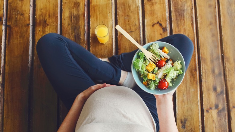 Pregnant woman with salad bowl