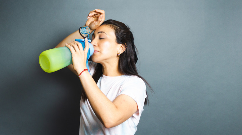 Woman drinking from water bottle