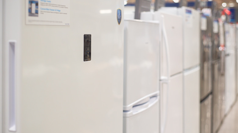 A line of modern refrigerators in a showroom