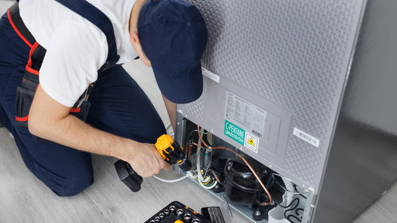 A technician installs a refrigerator