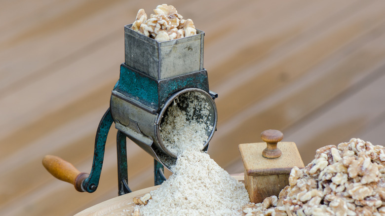 A hand-powered nut grinder processing walnuts